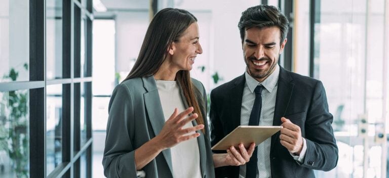 Two business people looking at a tablet in an office.